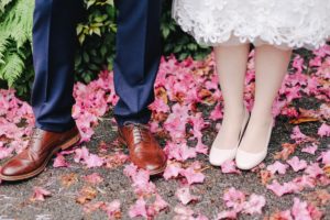 Flower pedals at the feet of groom and bride on the way to the reception with spring wedding food ideas by Aioli